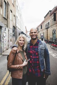 Portrait of loving multi-ethnic couple standing on city street