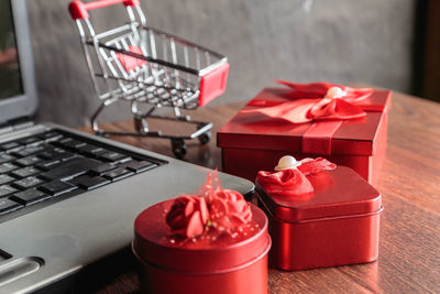 Close-up of red and laptop on table