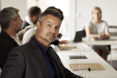 Businessman in boardroom looking at camera