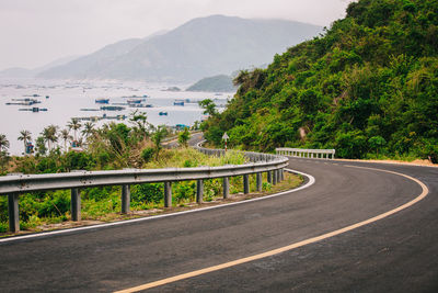 Road by sea against mountains in city