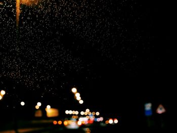 Defocused lights against sky at night