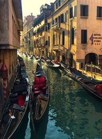 Boats in canal amidst buildings in city