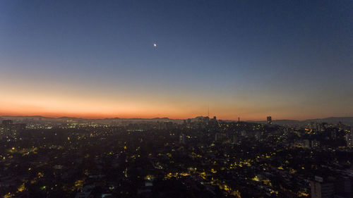 Illuminated cityscape against sky at night