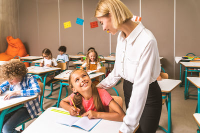 Teacher teaching student at classroom