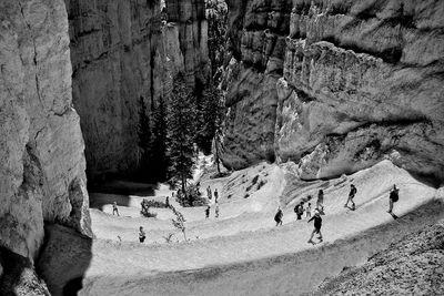 People walking on serpentine path on rock formation