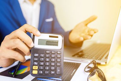 Close-up of man using smart phone on table