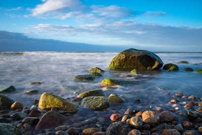 Pebbles on beach against sky