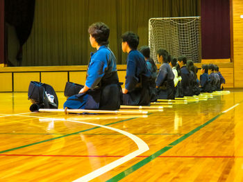 Martial art student sitting in row learning principles of self defence art