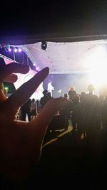 Low angle view of people standing in illuminated nightclub