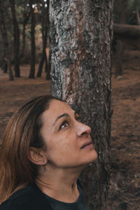 Portrait of woman on tree trunk