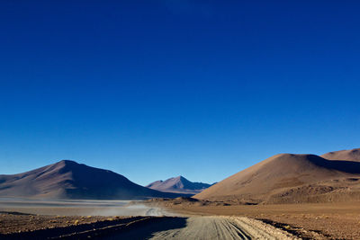 Scenic view of mountains against clear blue sky