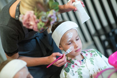 Beautician with girl at spa