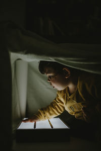 Side view of boy looking at book