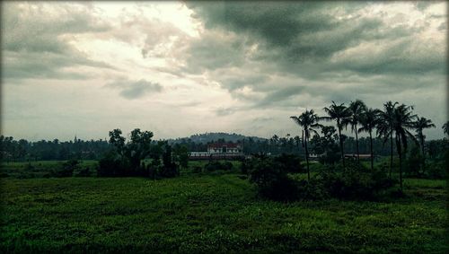 Scenic view of field against cloudy sky