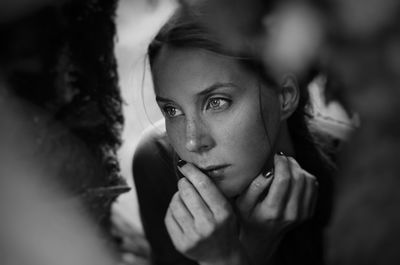 Close-up of young woman looking away seen through hole