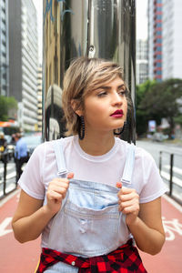 Beautiful young woman standing on street in city