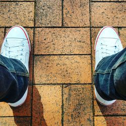 Low section of man standing on tiled floor