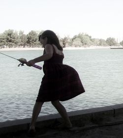 Silhouette of woman standing by lake