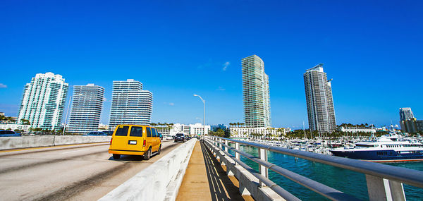 View of bridge and buildings against clear blue sky