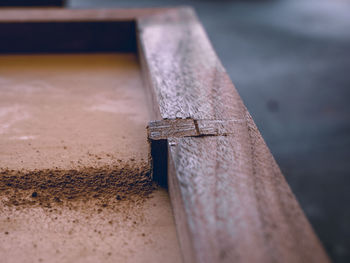 Close-up of sawdust left on the box after cutting the extra wood off the box