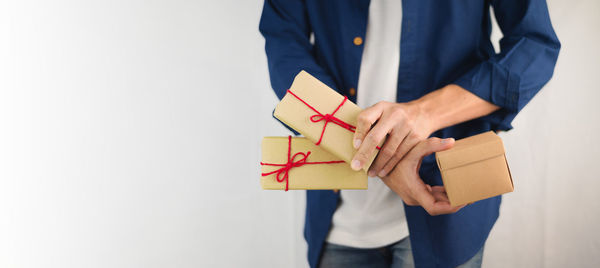 Midsection of man holding paper against white background