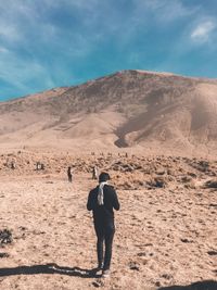 Rear view of young man walking towards mountain