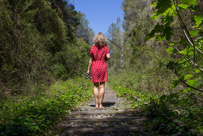 Rear view of woman walking on plants