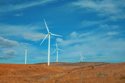 Windmill on field against sky