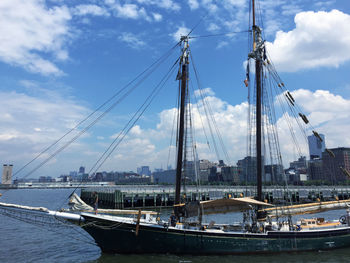 Sailboats in harbor against sky in city