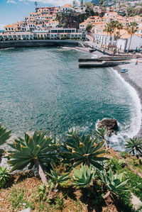 Scenic view of sea against buildings in city