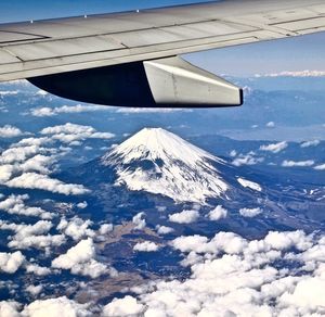 Cropped aircraft wing flying over mt fuji