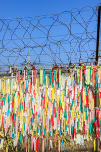 Multi colored umbrellas hanging against sky