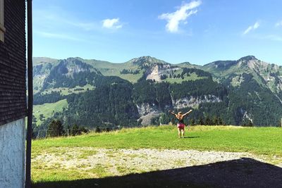 Man on field by mountains against sky