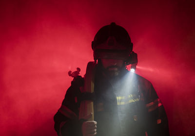 Close-up of firefighter against red light