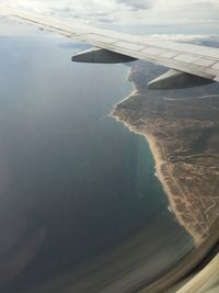 Cropped image of airplane wing over landscape