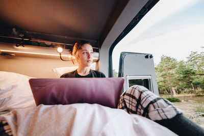 Young woman using laptop in camper
