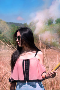 Woman holding distress flare on land