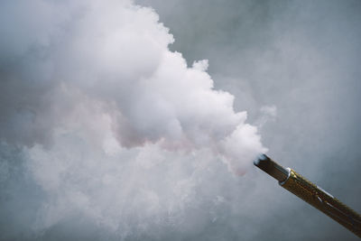 Low angle view of smoke stack against sky