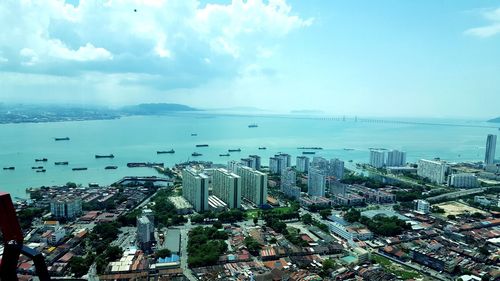 High angle view of cityscape by sea against sky