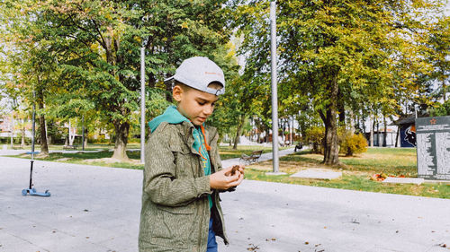 Boy standing on footpath at park