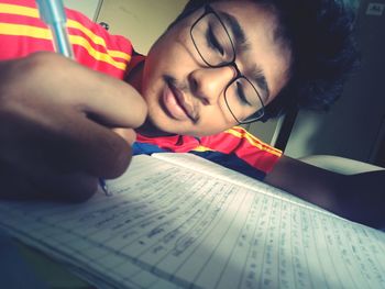 Close-up portrait of young woman reading book