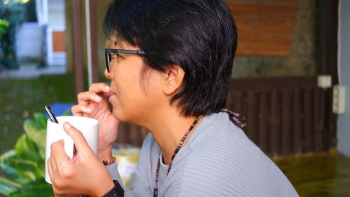 Side view of young woman using mobile phone