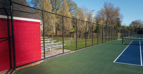 Empty tennis courts and empty spectator bench