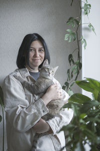Portrait of young woman holding cat