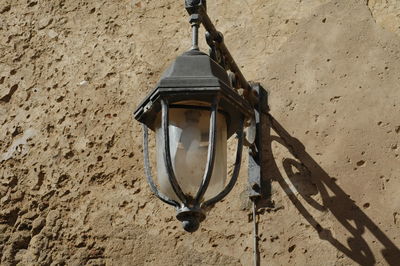 Low angle view of lamp mounted on old wall