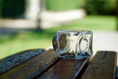 Transparent small bottle with coins on bench