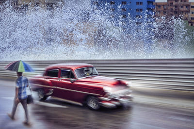 Havana, cuba old american classic car drive in after tropical rain on street in havana, cuba.