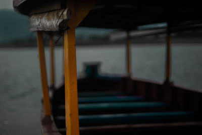 Close-up of metal railing by sea