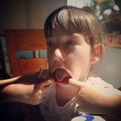 Close-up of girl making funny faces at home