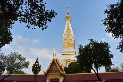 Low angle view of statue by building against sky